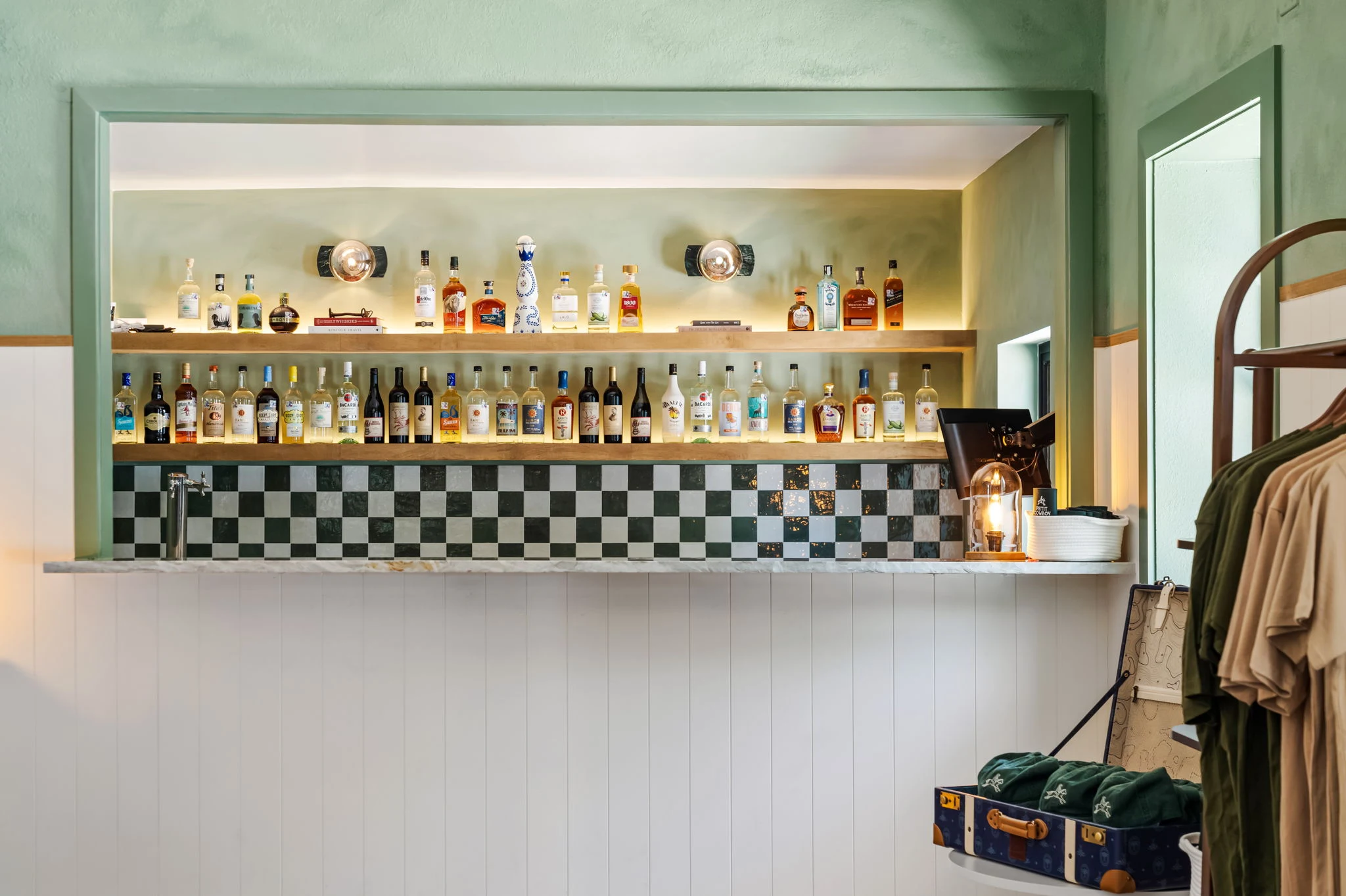 The bar, checkerboard tile & lit oak shelves at La Piscine, bar & restaurant in New Braunfels, Texas
